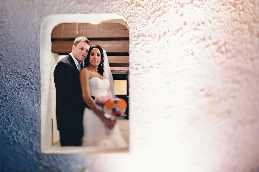 fix A couple sits closely on marble steps during their Jenn Paul engagement session, the man in a suit and the woman in a colorful dress, both smiling and looking at each other affectionately.