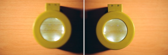 Digital camera with an articulated LCD screen, displayed on a wooden background, capturing real world use.
