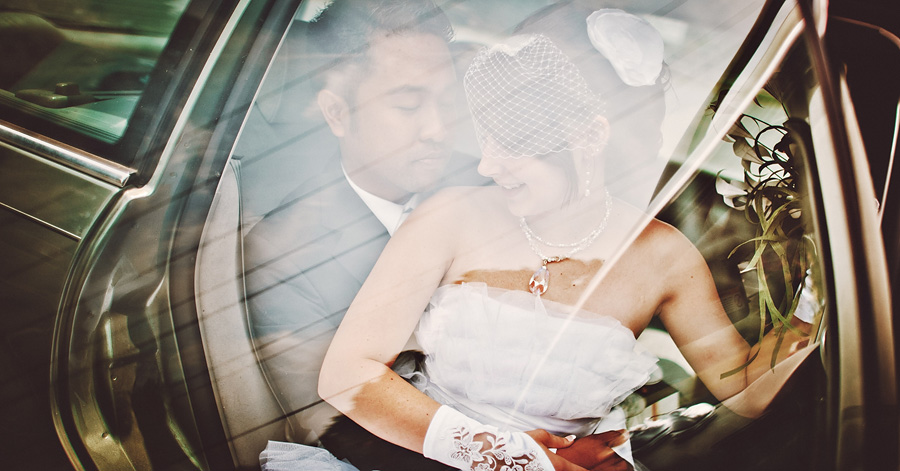bride and groom shooting through a car window