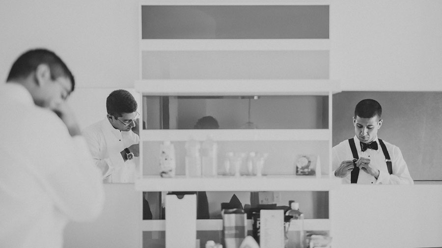 02 groom getting ready in hotel mirror 27