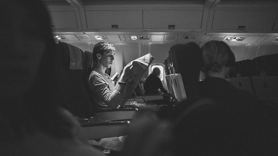 02 guy in airplane reading paper guy in airplane reading paper