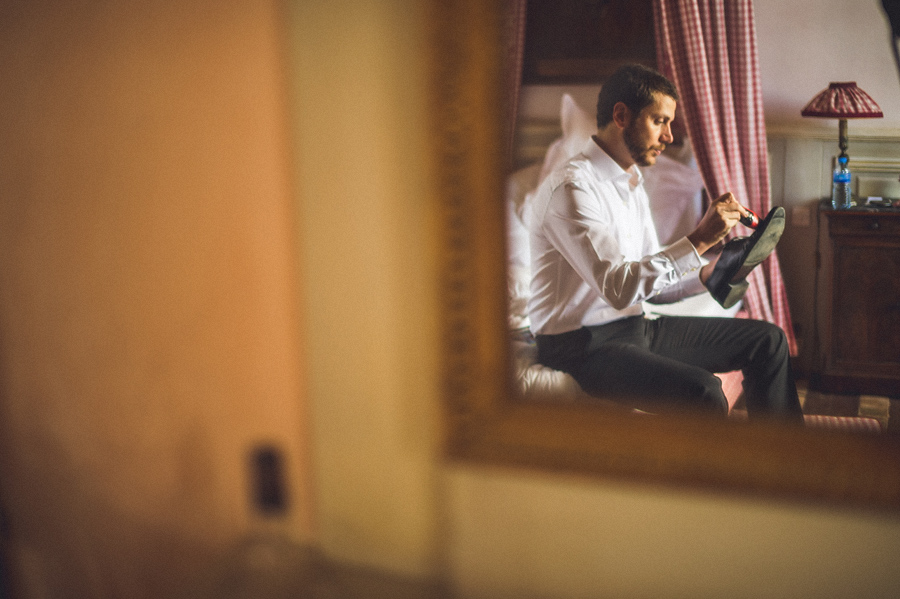 groomsmen cleaning shoes while getting ready