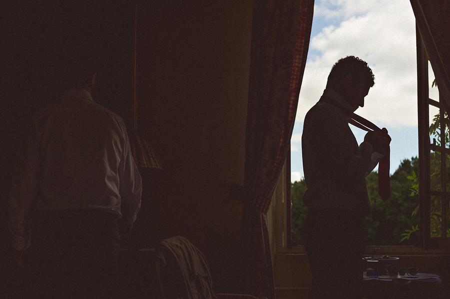 creative photo of groom putting on tie