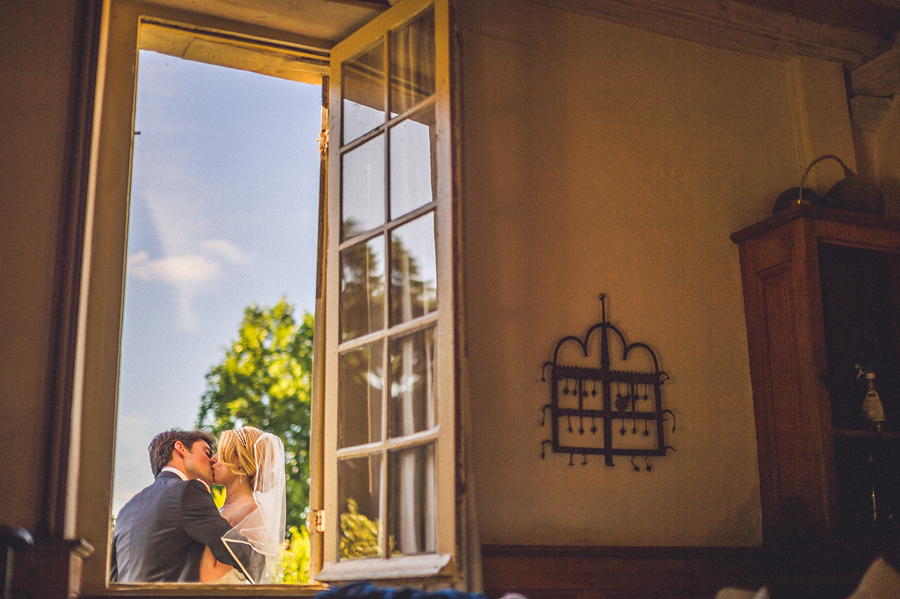 window photo of french groom and american bride