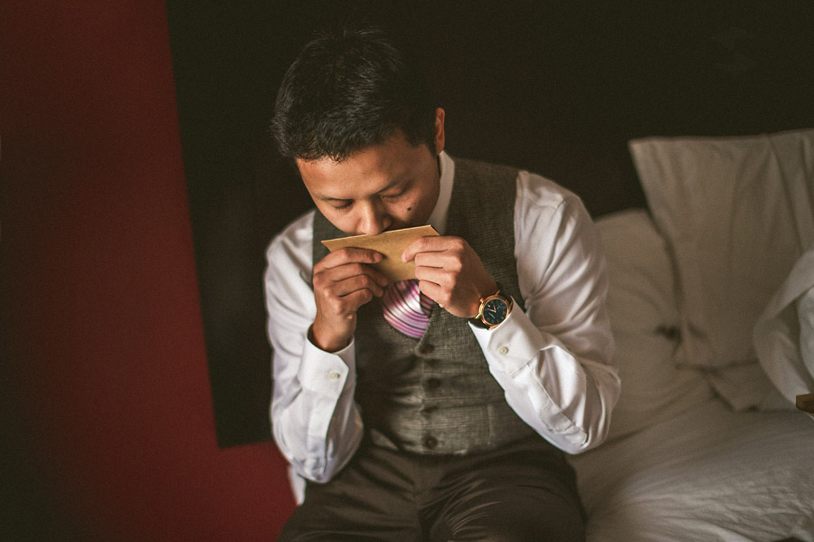 groom with letter from bride getting ready