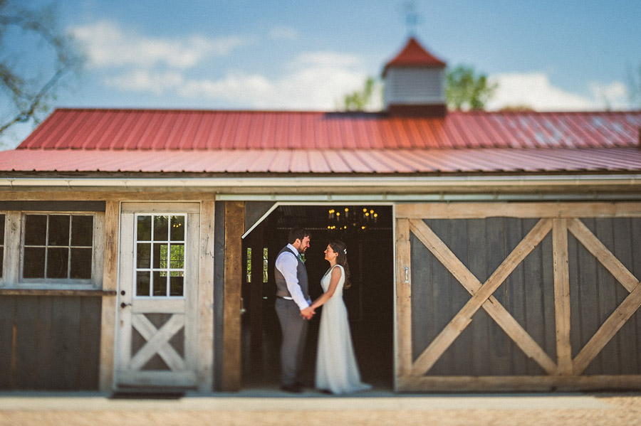 bride and groom standing in barn