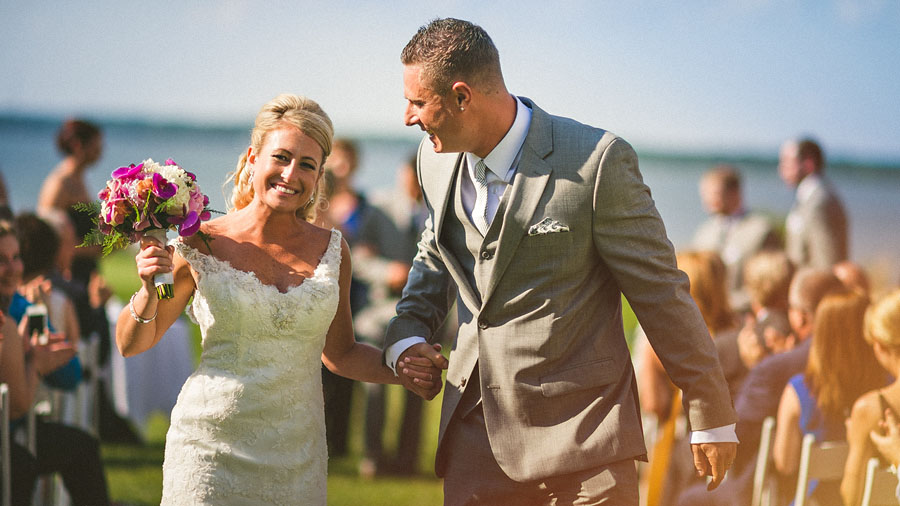 bride and groom laughing walking down aisle
