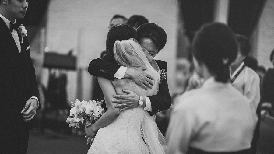 father of the bride hugging bride