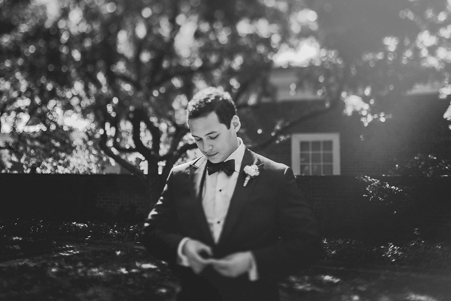 groom buttoning his jacket