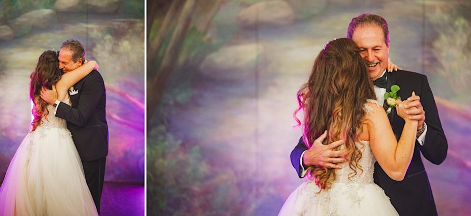 A father and bride share a joyful dance and embrace at an NYC Wedding reception, surrounded by a colorful backdrop.