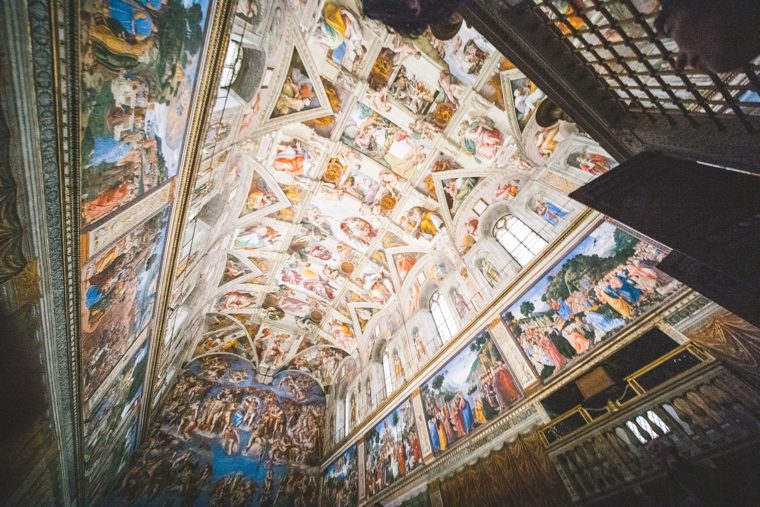 Interior view of the Sistine Chapel showing the detailed frescoes on the ceiling and walls, capturing scenes from biblical stories.