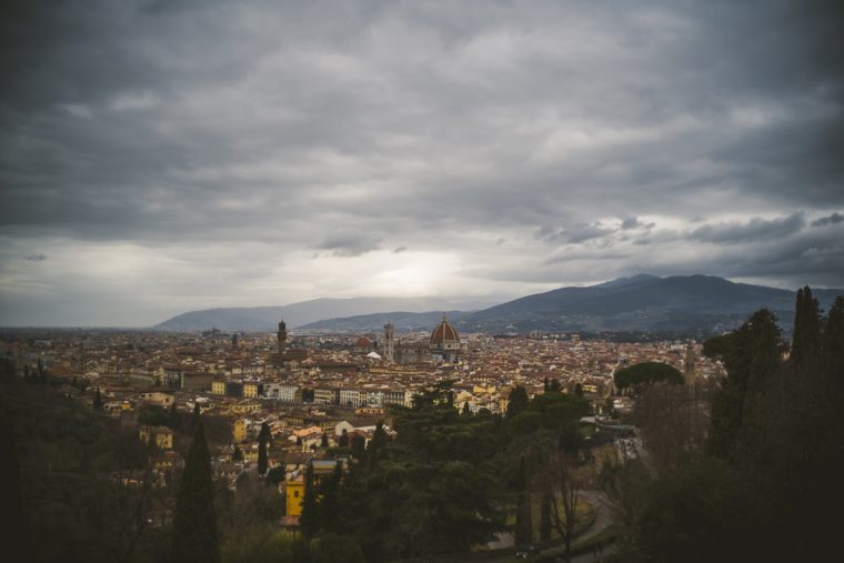 Overcast sky over a panoramic view of Florence, Italy, showcasing historical buildings and distant hills.