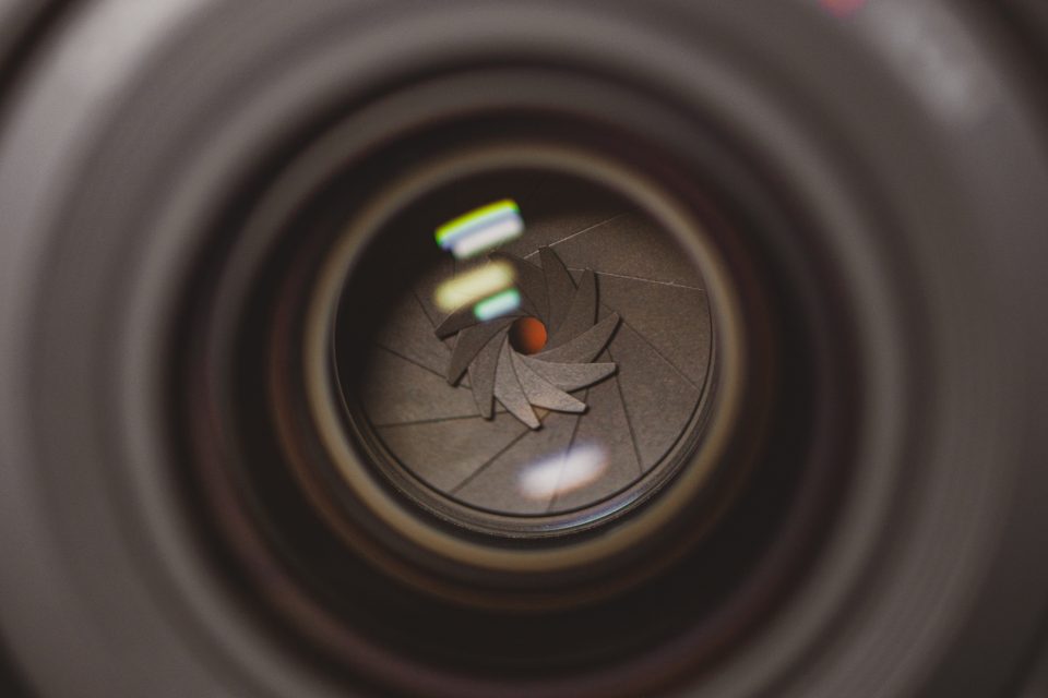 Close-up view of a Canon 35 1.4 VCM lens focusing on the aperture blades, showing various reflections and intricate details within the lens structure.