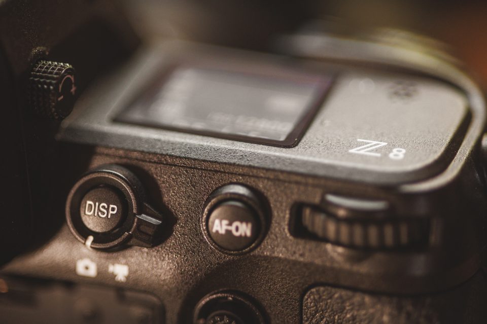 Close-up of a camera featuring the DISP and AF-ON buttons, with part of a display screen. The design ensures quick access to functions like Auto Draft for seamless shooting.