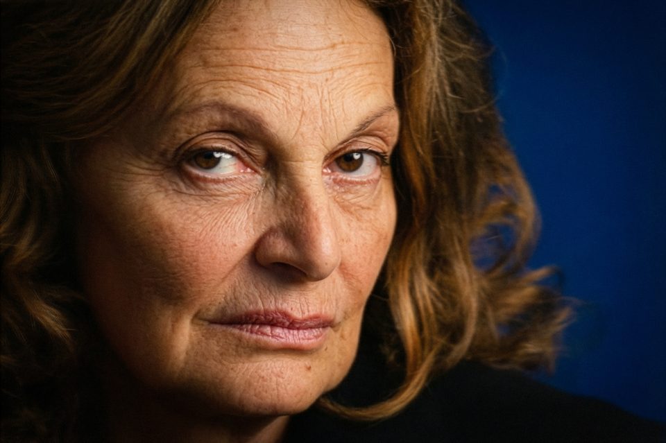 Close-up of an older woman with wavy brown hair and a serious expression, captured by a DC portrait photographer against a dark blue background. Close-up of an older woman with wavy brown hair and a serious expression, captured by a DC portrait photographer against a dark blue background.