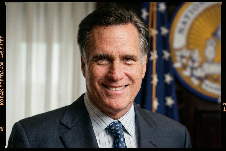 A man in a suit and tie smiles while standing indoors, with part of a flag and an official seal visible in the background—captured by a skilled DC portrait photographer. A man in a suit and tie smiles while standing indoors, with part of a flag and an official seal visible in the background—captured by a skilled DC portrait photographer.