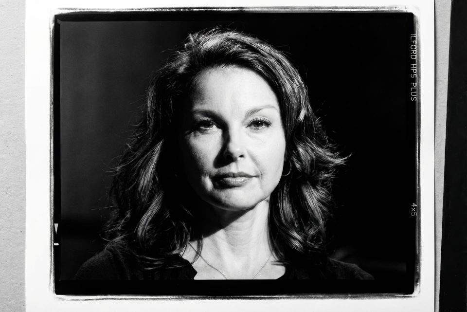 Black and white portrait by a DC portrait photographer featuring a woman with wavy hair gazing directly at the camera, set against a dark background. Black and white portrait by a DC portrait photographer featuring a woman with wavy hair gazing directly at the camera, set against a dark background.