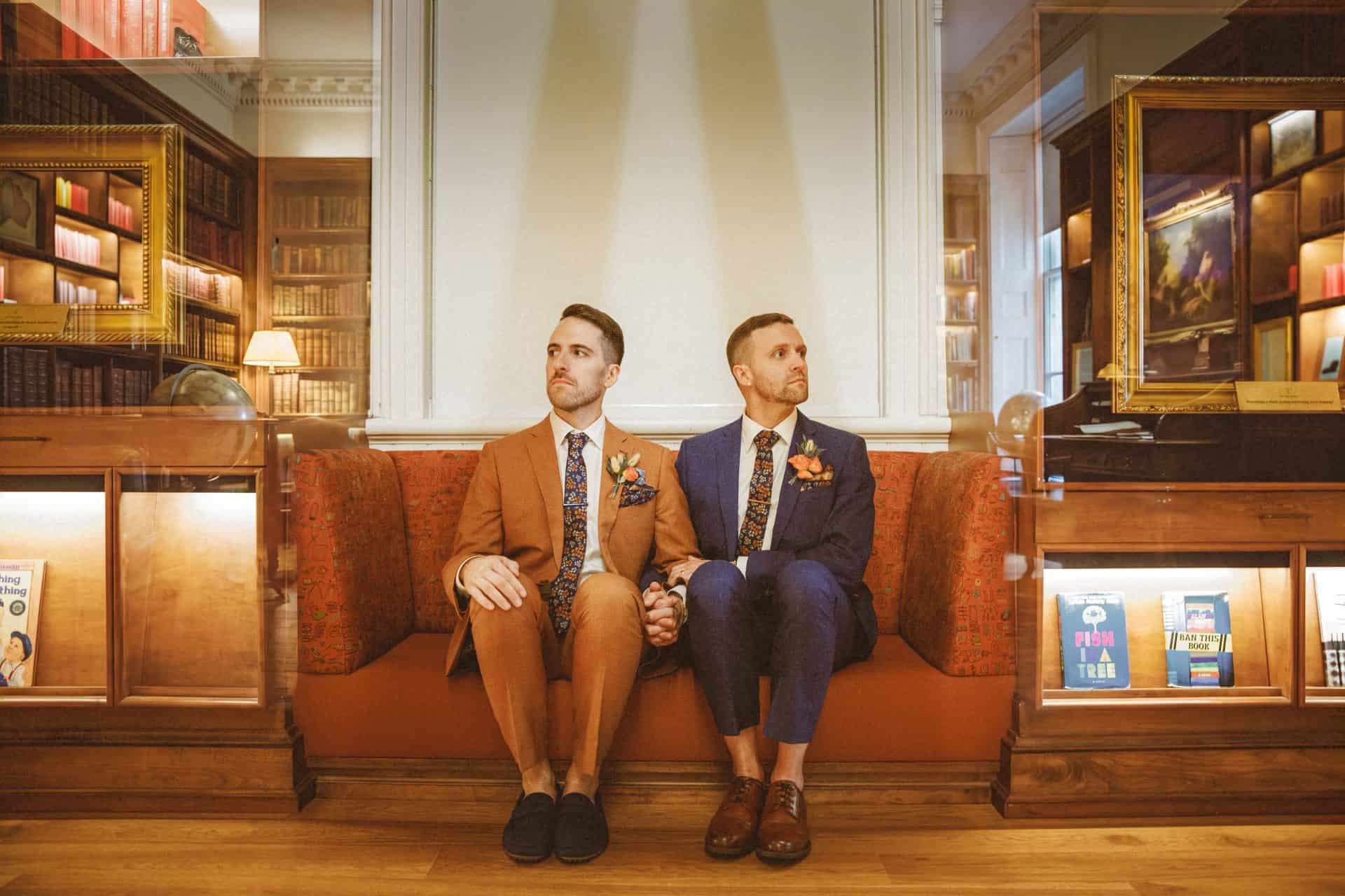 Two grooms face to face in silhouette with a warm radial blur at a Planet Word wedding
